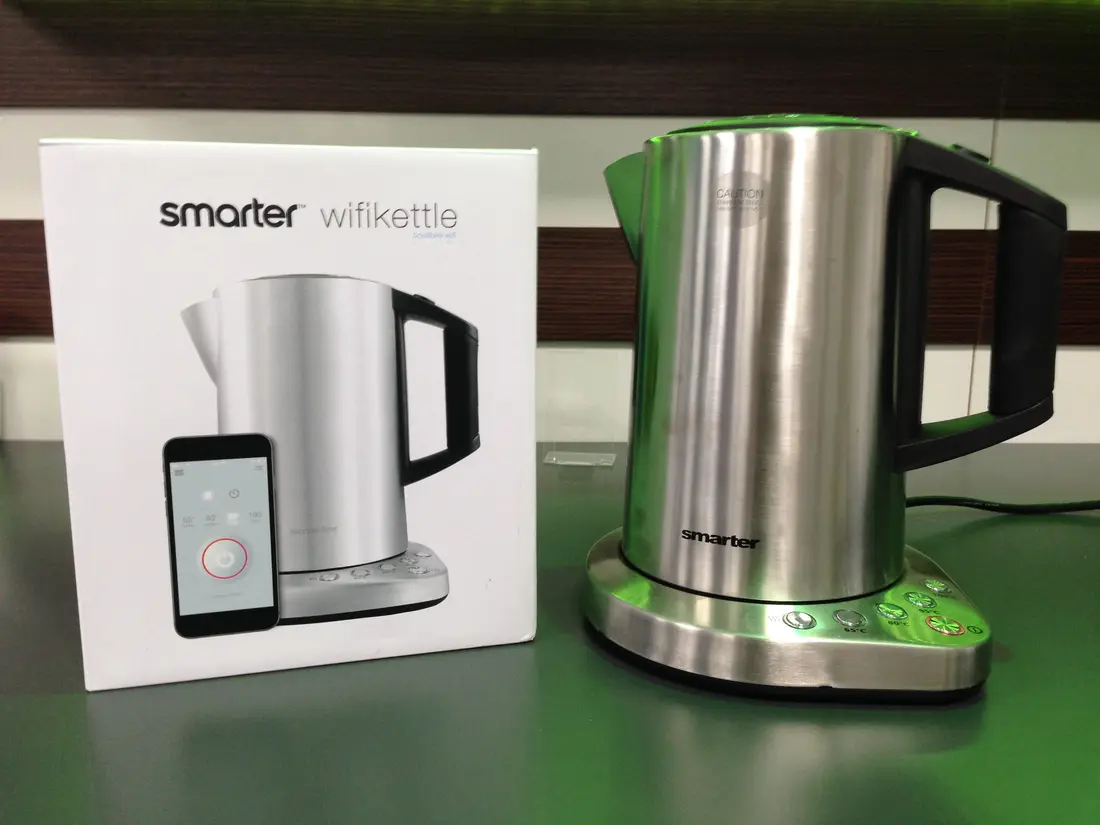 Stainless-steel Wi-Fi kettle beside packaging showing its smartphone app